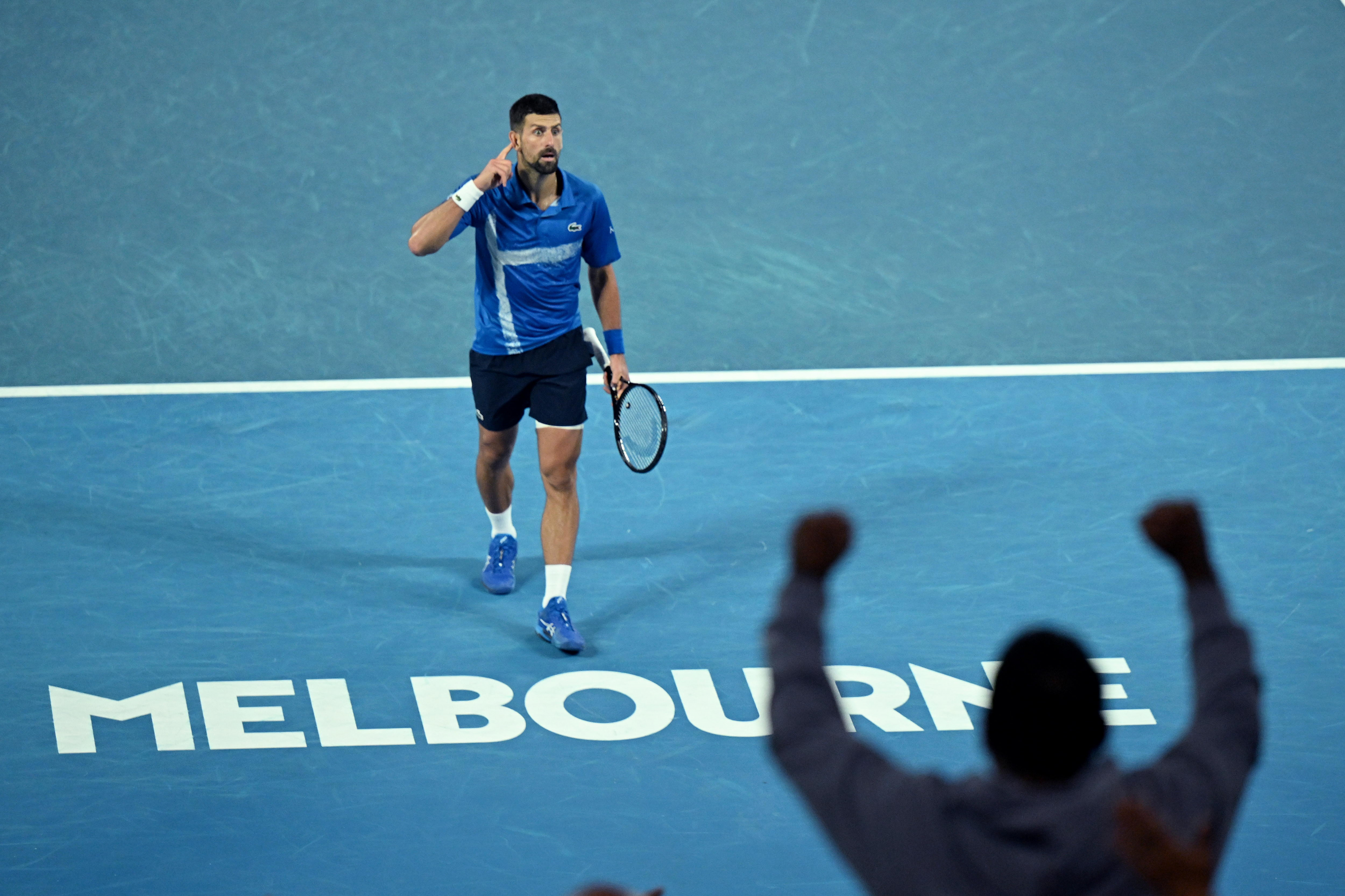 Novak met la main à son oreille pour écouter les fans.