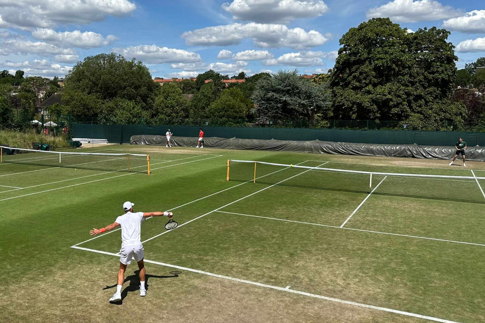 Djokovic s'entraîne sur la piste à côté d'Alcaraz.