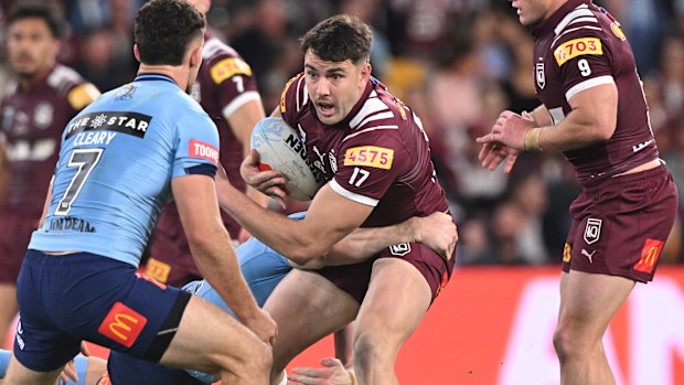 Trent Loiero tente d'échapper à la ligne défensive du blues alors qu'il dirige le ballon pour le Queensland.