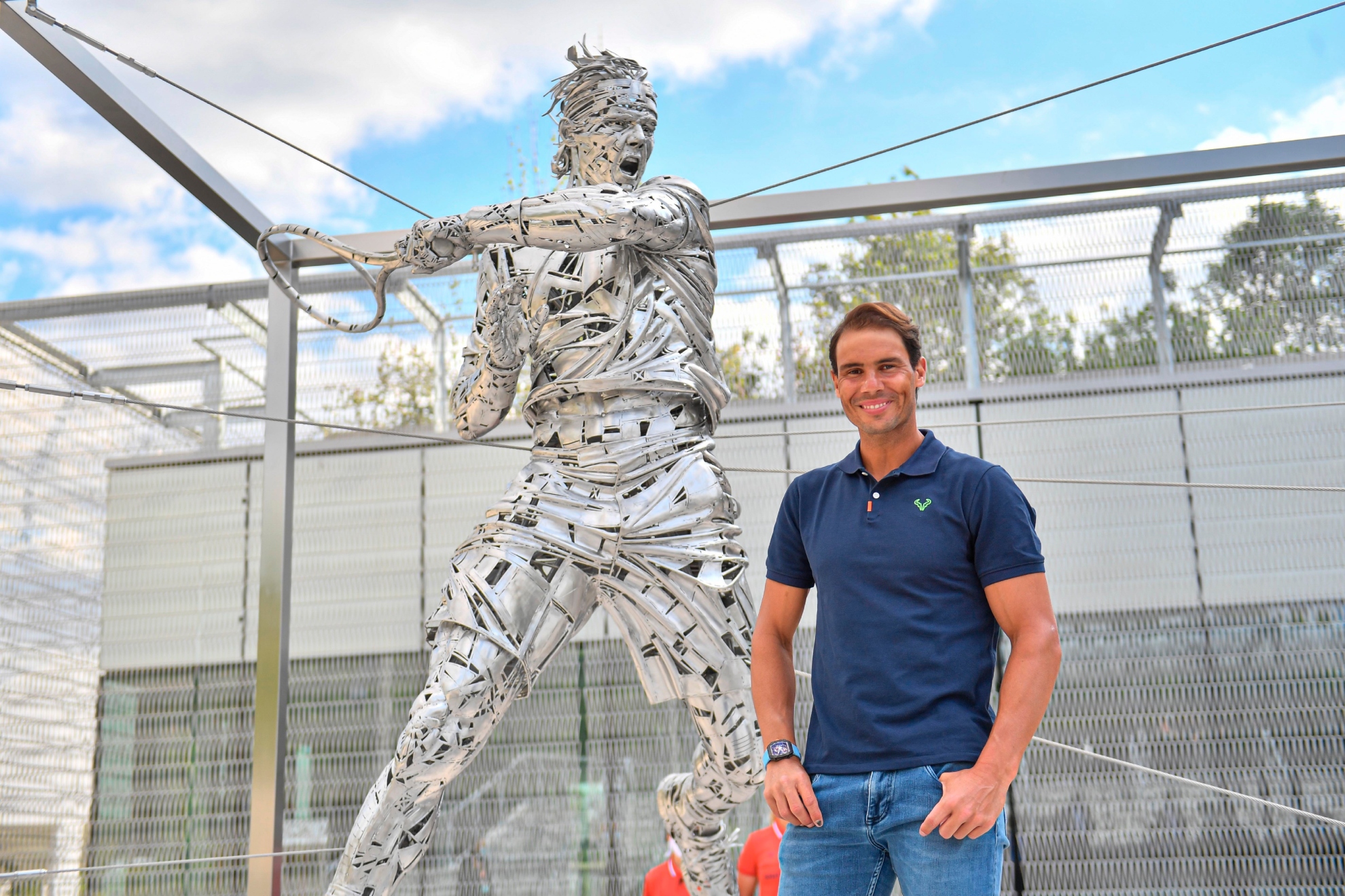 Rafa Nadal posant devant sa statue à Roland Garros.